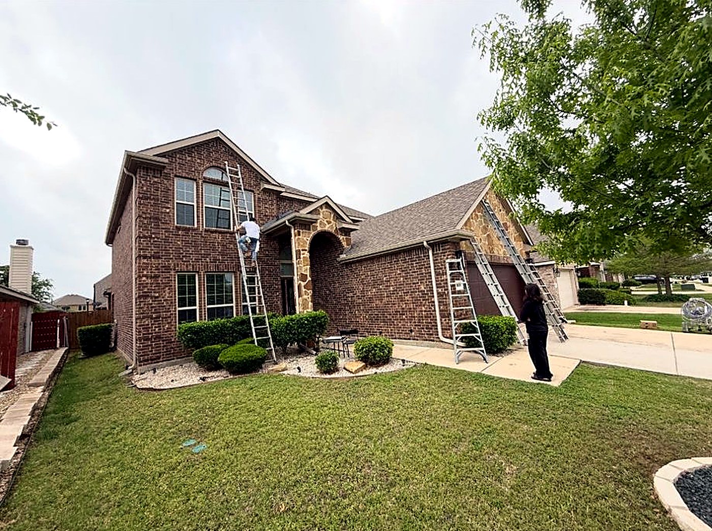 H&C Solutions crew painting a home exterior